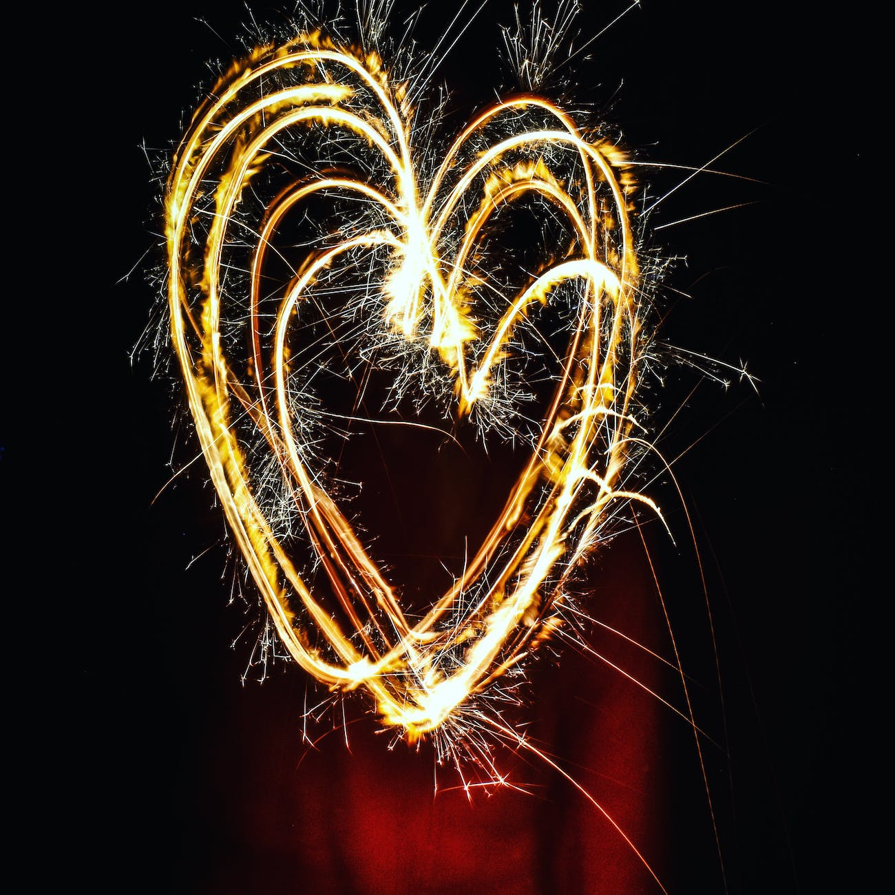 Fiery, sparkly loops of electric light form multiple loops in the shape of hearts.